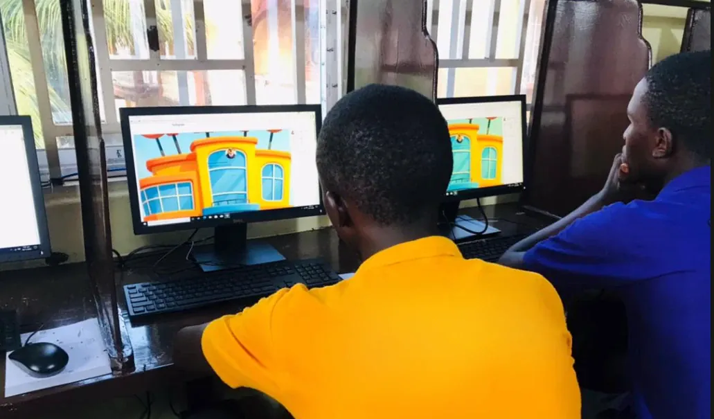 Students working side by side at a row of laptops, following a Capyo lesson in their classroom